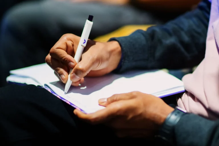 A person writing down their personal vision statement in a notebook