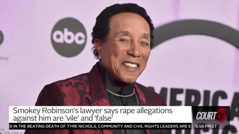 Older Black gentleman on a red carpet wears a snazzy red silk jacket